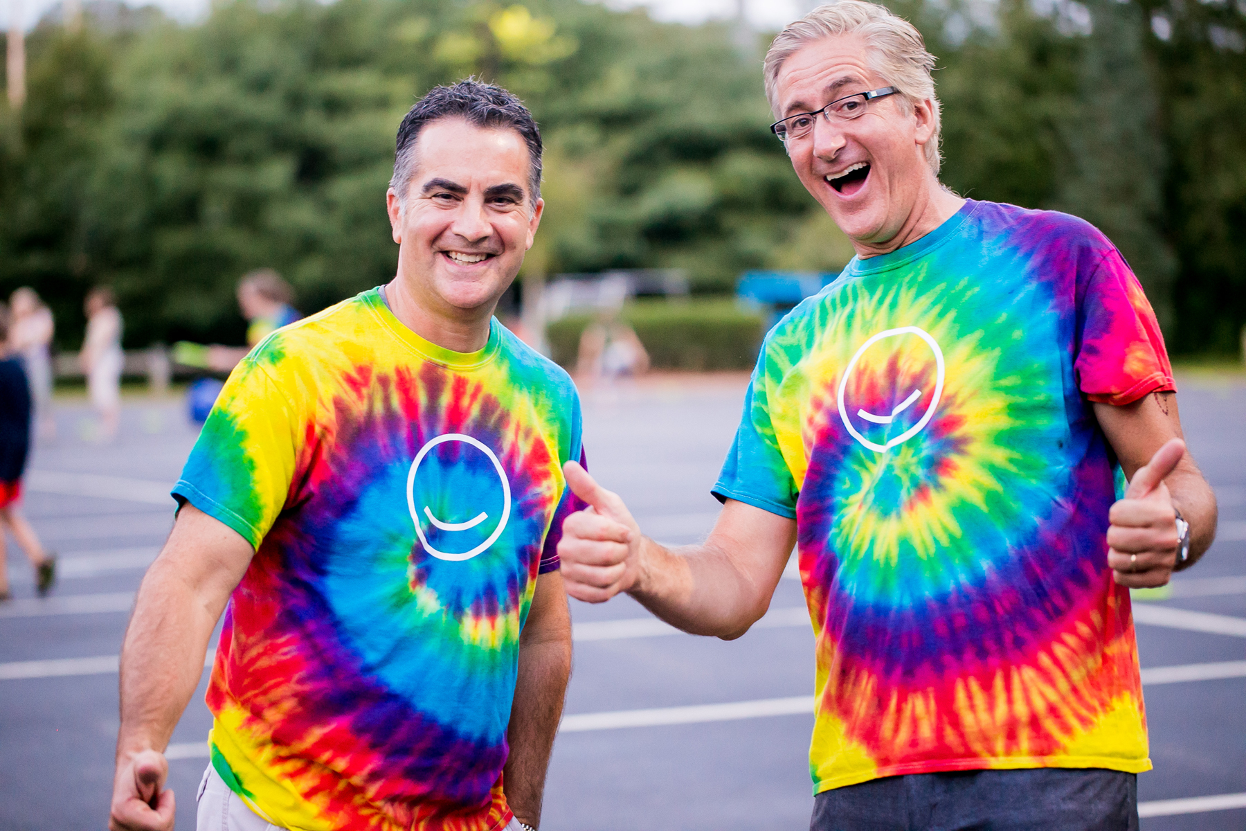 Dr. O'Leary and Dr. Hack smiling in a parking lot, wearing tie-dye OASECT tee shirts on movie night