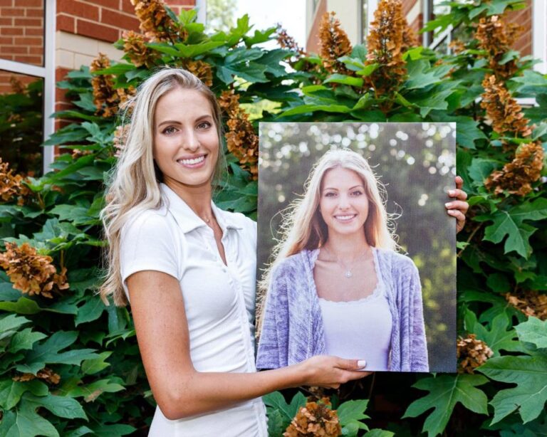 Woman who has finished orthodontic treatment holding a picture of herself prior to treatment
