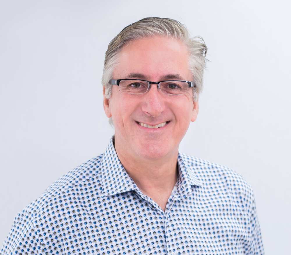 Connecticut Orthodontist Dr. Gregory Hack smiling in a blue and purple dotted shirt