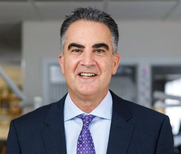 Connecticut Orthodontist Dr. James O’Leary smiling in a suit and purple tie