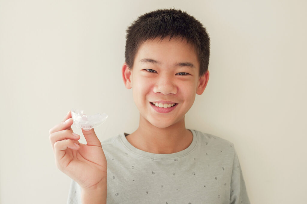 Handsome young man holding his clear customized mouth guard