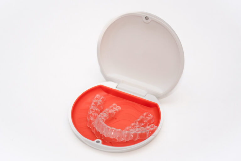 Set of translucent Vivera® retainers in a magma orange and white case