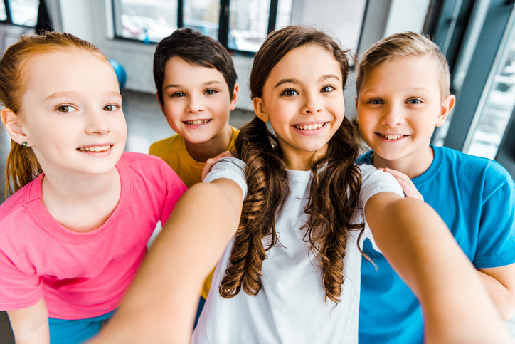 4 young children smiling together in a selfie